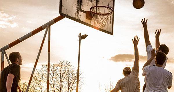 photo of men playing basketball outdoors