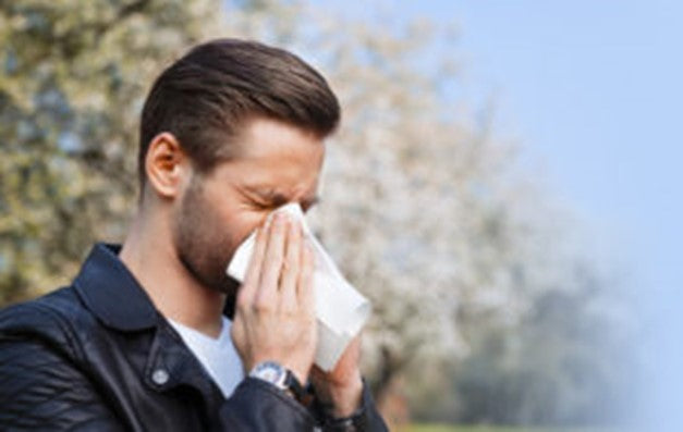 Image of man blowing his nose
