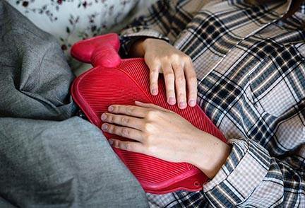 photo of woman with hot water bottle on stomach