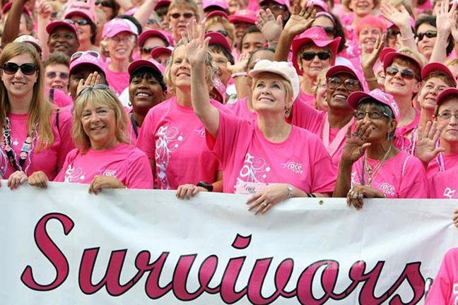 photo of ladies wearing pink and holding a "Survivior" banner