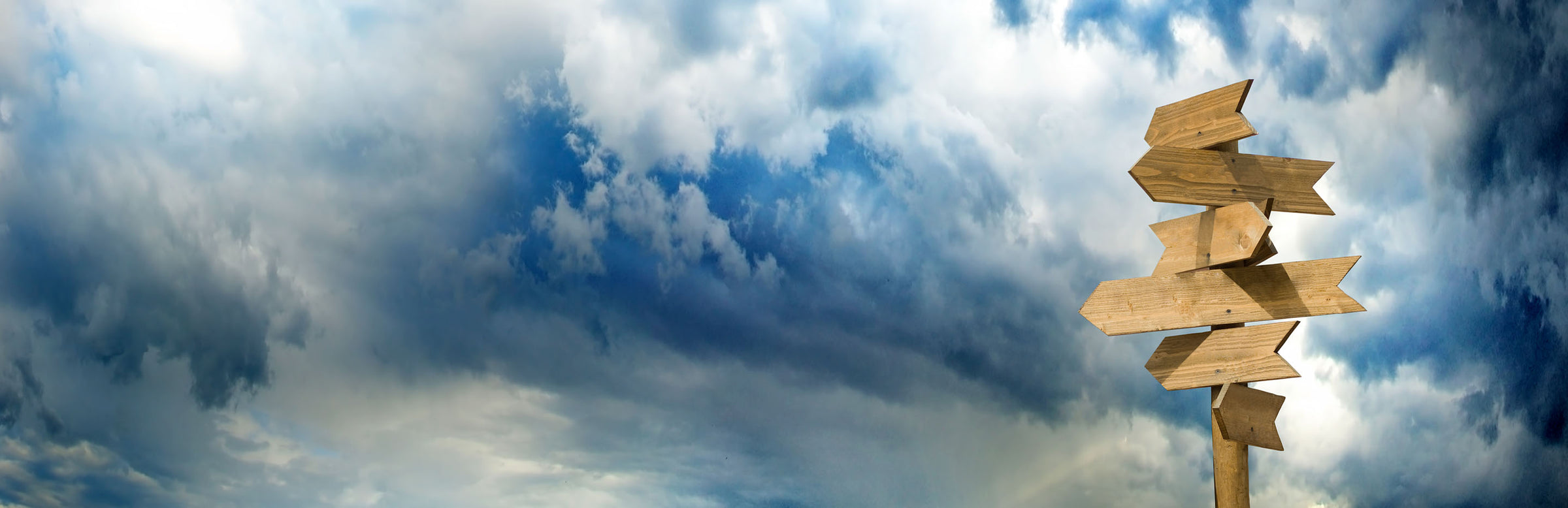 Wooden Signposts against a turbulent sky